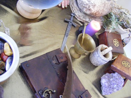 Table adorned with materials and objects related to spell casting and spirituality.