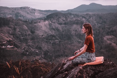 Woman meditating on a hilltop
