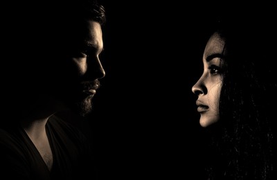 A man and woman facing each other looking tense.