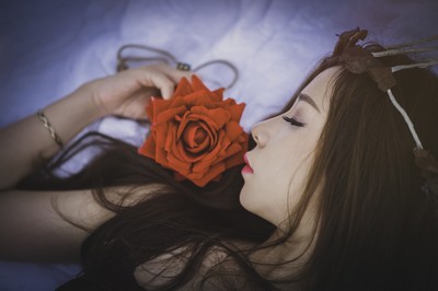 Girl asleep with a red rose.