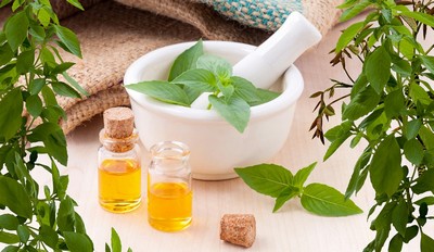 Pestle and mortar, small bottles and herbs.