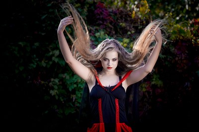 A woman in the woods holding up her long hair. A woman in the woods holding up her long hair.
