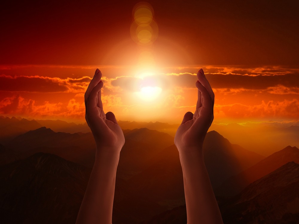 Hands seemingly cradling the Sun. Hands seemingly cradling the Sun.