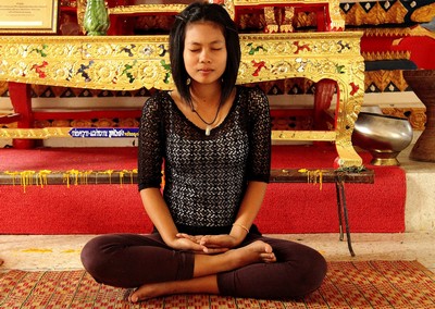 woman sat meditating in lotus position