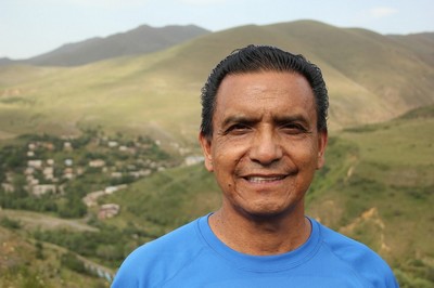 A person standing in front of a mountainous landscape.