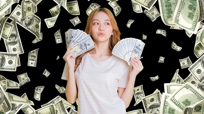 Woman holding money surrounded by cascading bank notes.