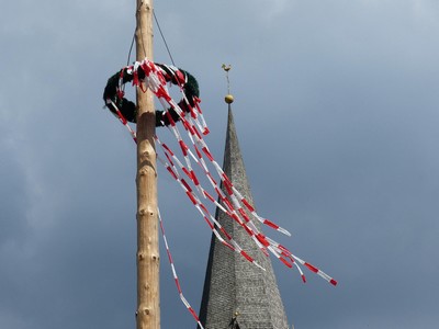 Picture of a Maypole set against a grey sky.