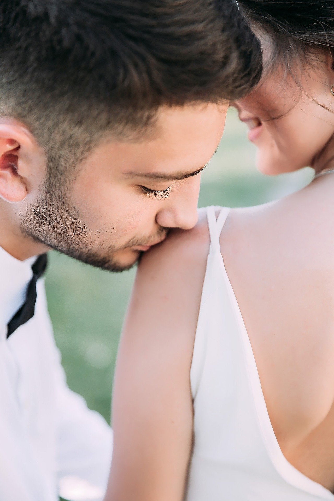 Man kisses lover on shoulder