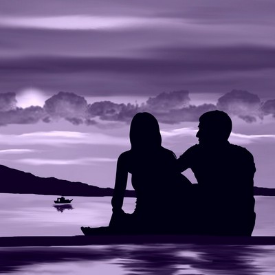 Loving couple in silhouette sat by a lake