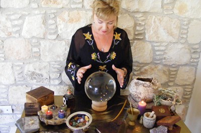 A woman at an Altar staring into a crystal ball.