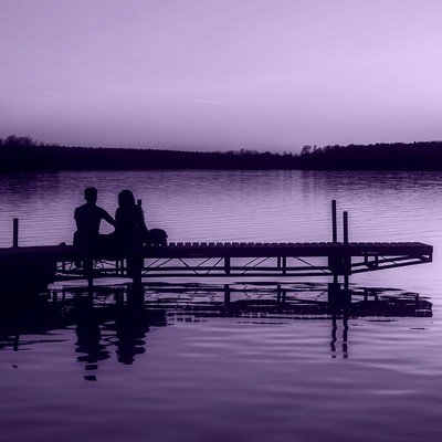 Loving couple sat on a jetty