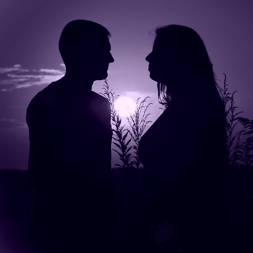 Loving couple in silhouette with sunset behind