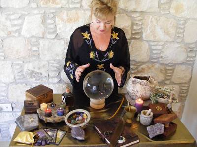 A woman at an Altar staring into a crystal ball.