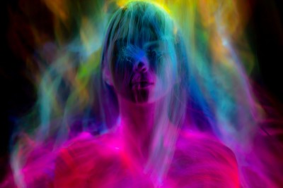 Multi-colored smoke surrounding woman