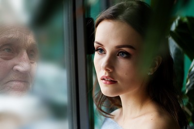 Young woman next to the reflection of an old man