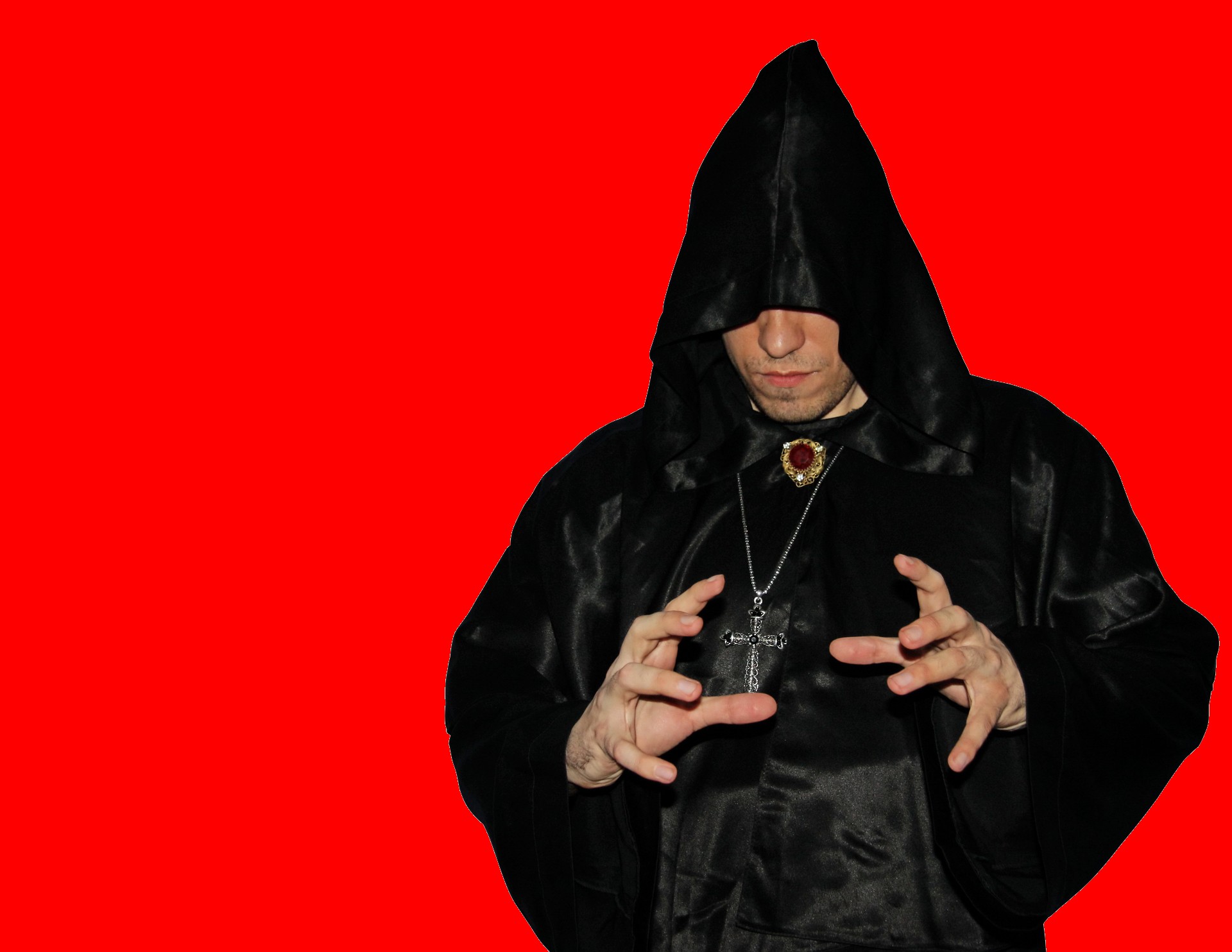 Hooded man dressed in black with a red background