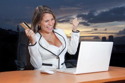 Successful Business Woman expressing joy in front of her computer.